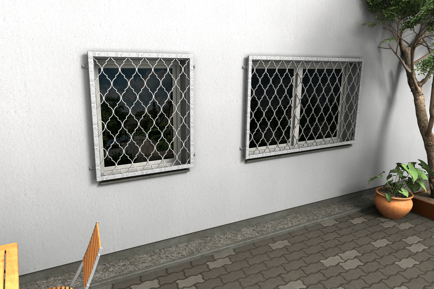 Zwei Fenstergitter aus feuerverzinktem Stahl mit dekorativem Ornamentmuster als Einbruchschutz an einer Hausfassade