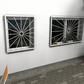 Zwei Fenstergitter Atlas 15 aus feuerverzinktem Stahl mit radialem Strahlenmuster als Einbruchschutz an einer Hausfassade