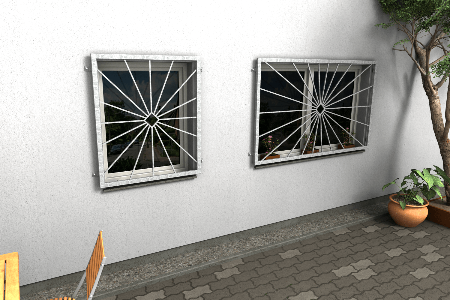 Zwei Fenstergitter Atlas 15 aus feuerverzinktem Stahl mit radialem Strahlenmuster als Einbruchschutz an einer Hausfassade