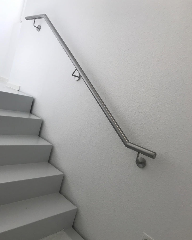 Wandhandlauf aus Edelstahl im Treppenhaus, oben abgewinkelt, auf drei Wandhaltern